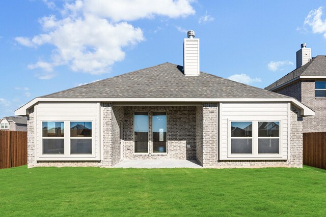 back of house featuring a lawn and a patio area