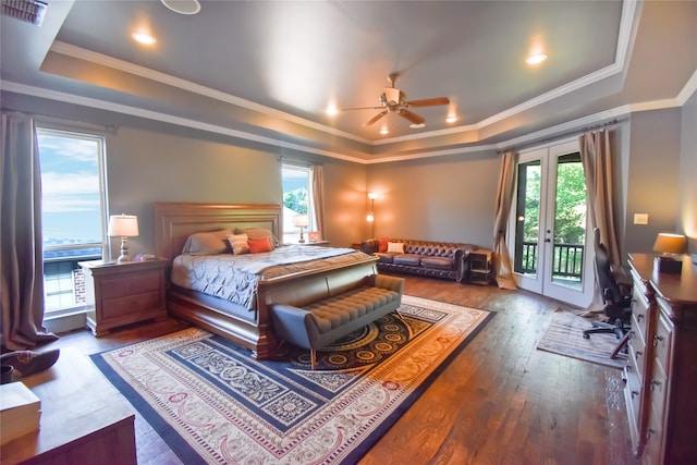 bedroom with access to exterior, a raised ceiling, wood-type flooring, and french doors