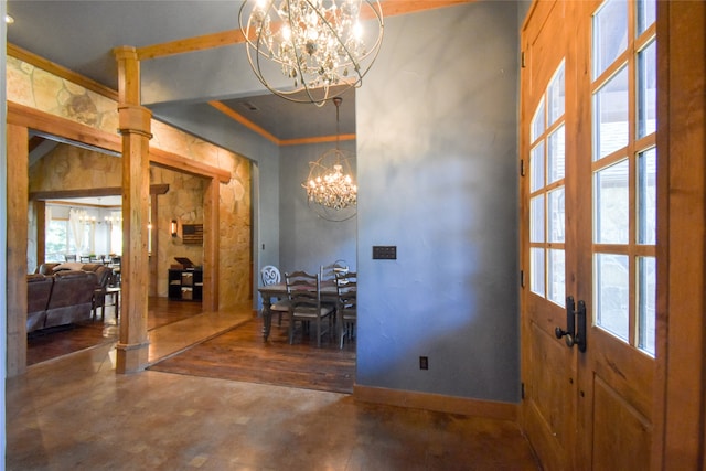 foyer featuring concrete flooring, an inviting chandelier, crown molding, and french doors