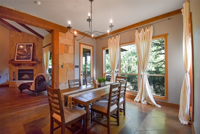 dining space featuring dark tile patterned floors, vaulted ceiling with beams, a notable chandelier, and a stone fireplace