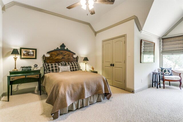 carpeted bedroom with lofted ceiling, ceiling fan, a closet, and ornamental molding