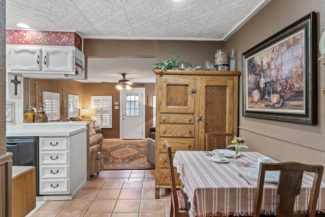 interior space featuring ceiling fan, light tile patterned flooring, dishwasher, and white cabinets