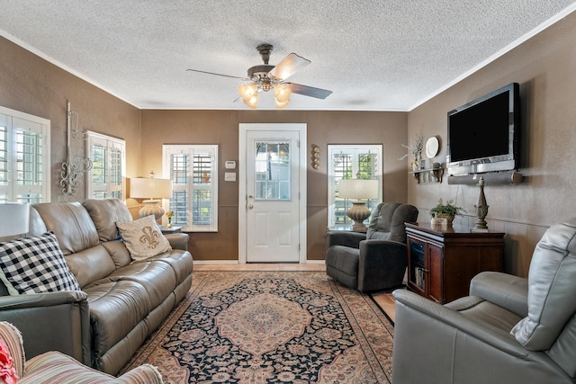 tiled living room with ceiling fan, a healthy amount of sunlight, crown molding, and a textured ceiling