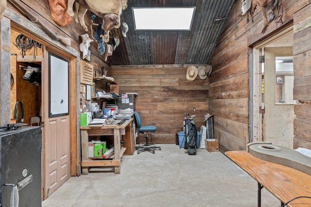 interior space with concrete floors, lofted ceiling, and wood walls