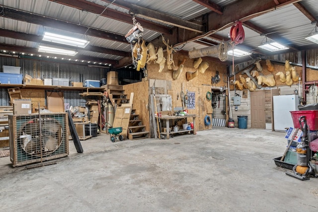 garage featuring white refrigerator and a workshop area