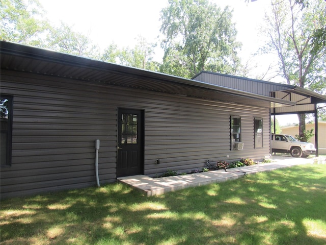 back of house with a lawn and a carport