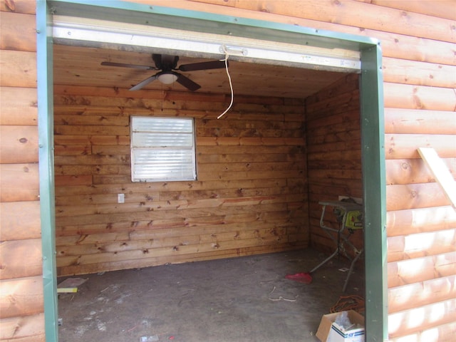 interior space featuring ceiling fan and log walls