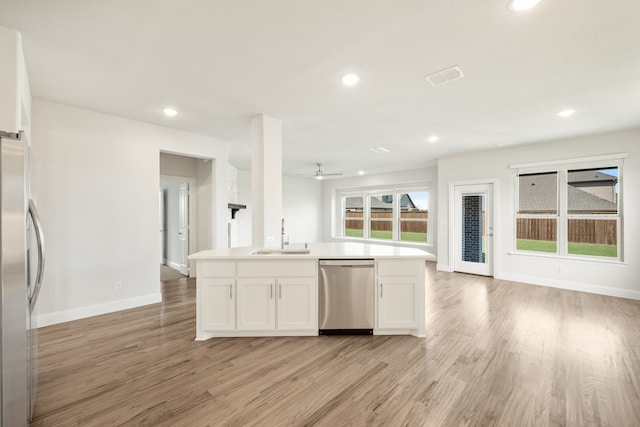 kitchen featuring appliances with stainless steel finishes, sink, light wood-type flooring, ceiling fan, and white cabinets