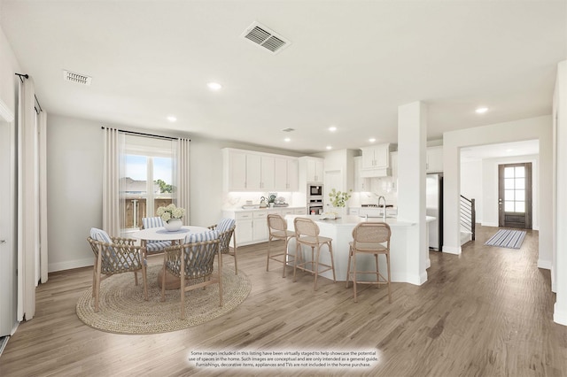 dining space with light hardwood / wood-style floors and sink