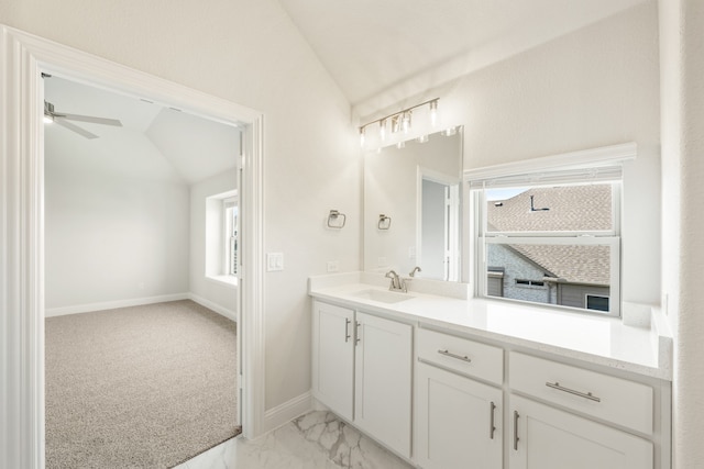 bathroom featuring vanity, ceiling fan, and vaulted ceiling