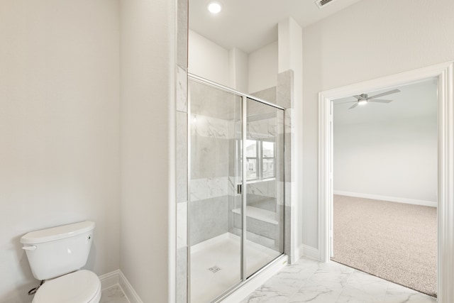 bathroom with a shower with shower door, toilet, and ceiling fan