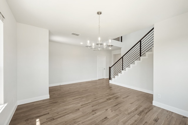 unfurnished room featuring a chandelier and hardwood / wood-style floors