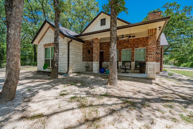 rear view of house with ceiling fan and a patio area