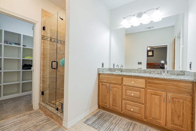 bathroom with vanity, a shower with shower door, and tile patterned floors