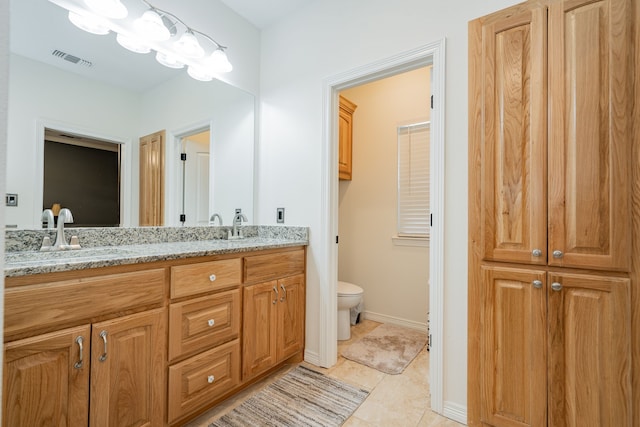 bathroom with vanity, tile patterned flooring, and toilet