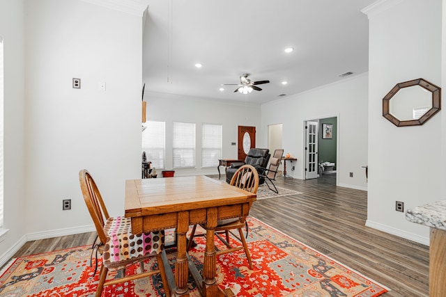 dining area featuring crown molding, ceiling fan, and dark wood-type flooring