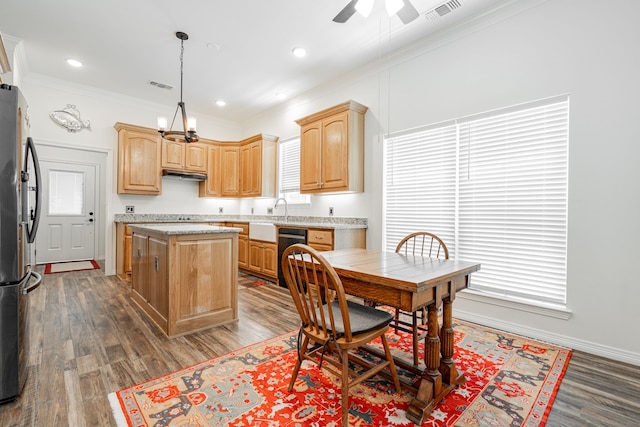 kitchen featuring pendant lighting, stainless steel fridge, black dishwasher, ornamental molding, and a kitchen island