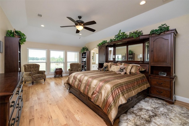 bedroom featuring arched walkways, light wood-type flooring, baseboards, and recessed lighting