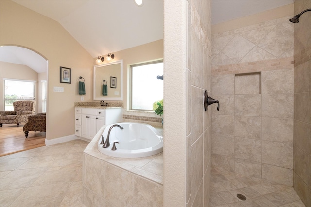 bathroom with tile patterned flooring, a garden tub, vanity, vaulted ceiling, and a tile shower