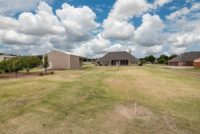 view of yard featuring a garage, an outbuilding, and an outdoor structure