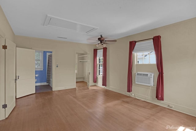 empty room featuring ceiling fan, cooling unit, and hardwood / wood-style flooring