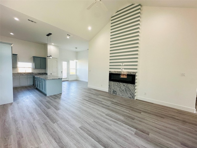 unfurnished living room featuring high vaulted ceiling, ceiling fan, and wood-type flooring