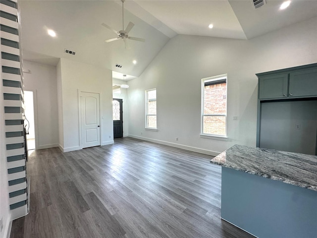 unfurnished living room with ceiling fan, high vaulted ceiling, and dark hardwood / wood-style floors