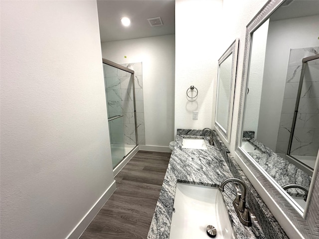 bathroom with wood-type flooring, vanity, and a shower with shower door