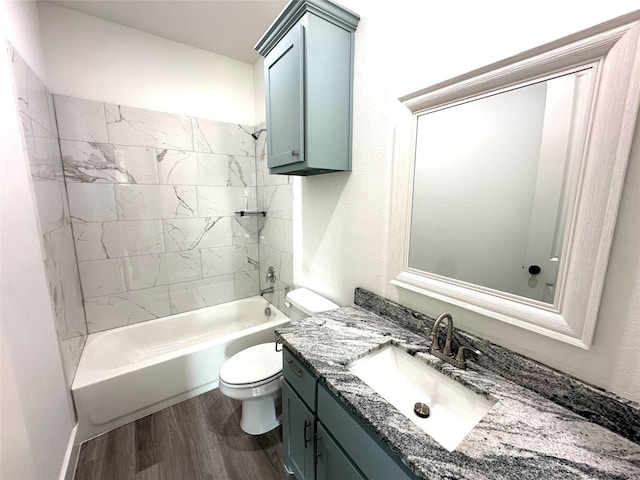 full bathroom with toilet, tiled shower / bath combo, vanity, and hardwood / wood-style floors