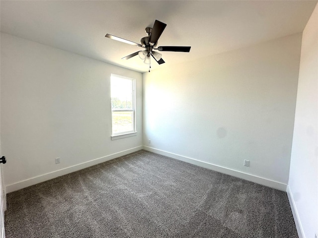 spare room featuring ceiling fan and dark carpet