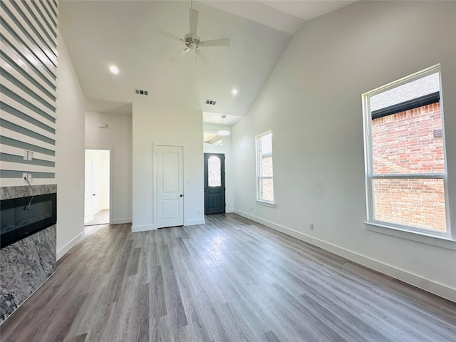 unfurnished living room featuring high vaulted ceiling and a wealth of natural light