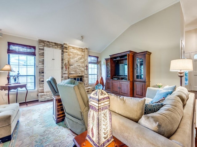 living room with a fireplace, vaulted ceiling, and a wealth of natural light