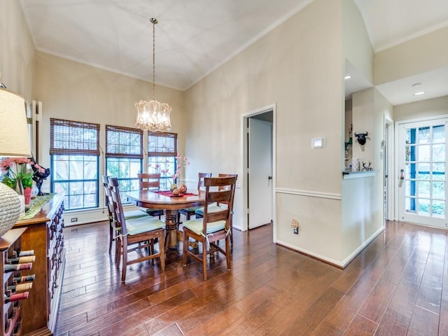 dining room featuring a towering ceiling, dark wood-type flooring, and an inviting chandelier