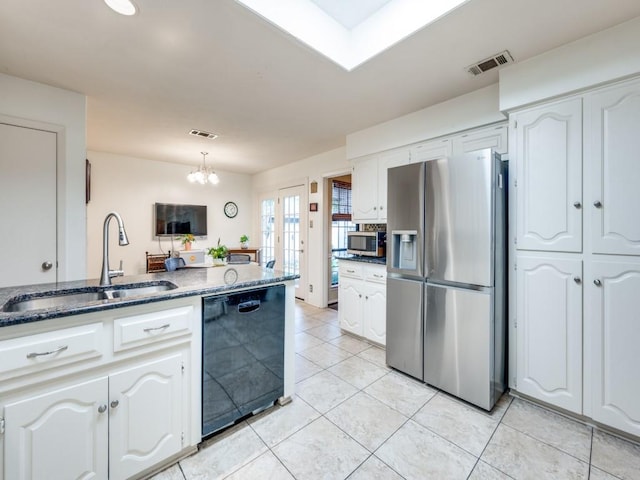 kitchen featuring stainless steel appliances, sink, decorative light fixtures, white cabinetry, and a notable chandelier