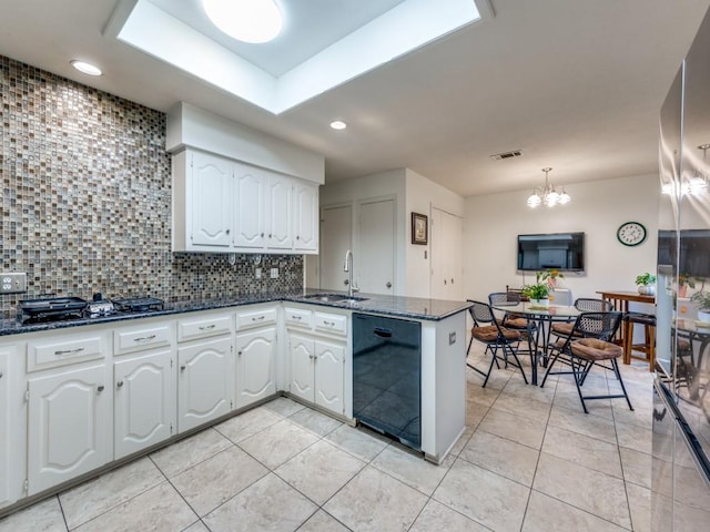 kitchen with dishwasher, hanging light fixtures, kitchen peninsula, white cabinetry, and tasteful backsplash