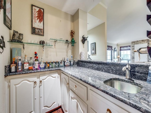 kitchen featuring sink, white cabinetry, and dark stone countertops