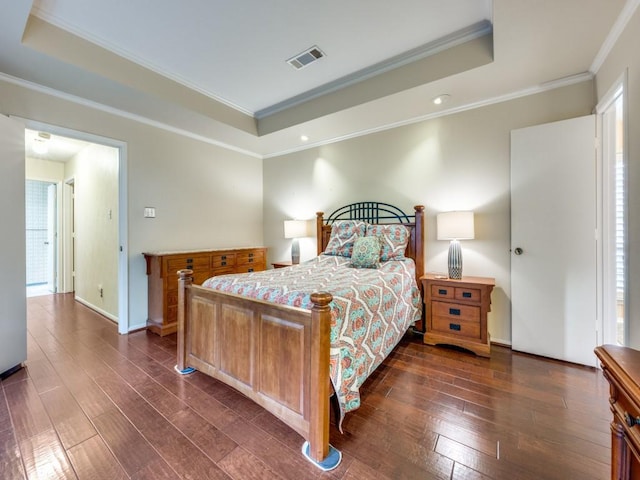 bedroom featuring a tray ceiling, crown molding, and dark wood-type flooring