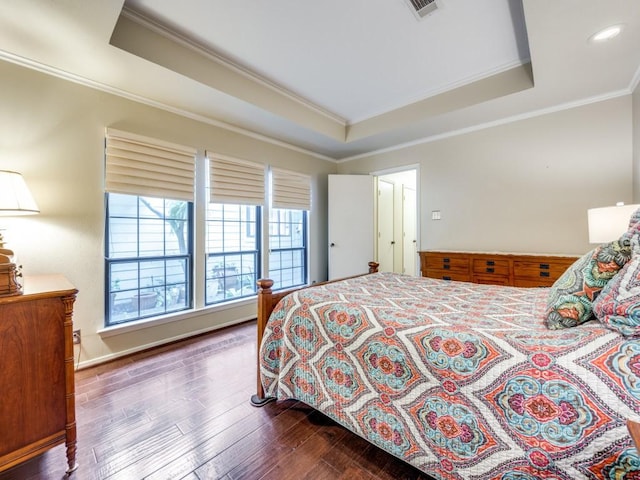 bedroom featuring ornamental molding, a raised ceiling, and hardwood / wood-style flooring