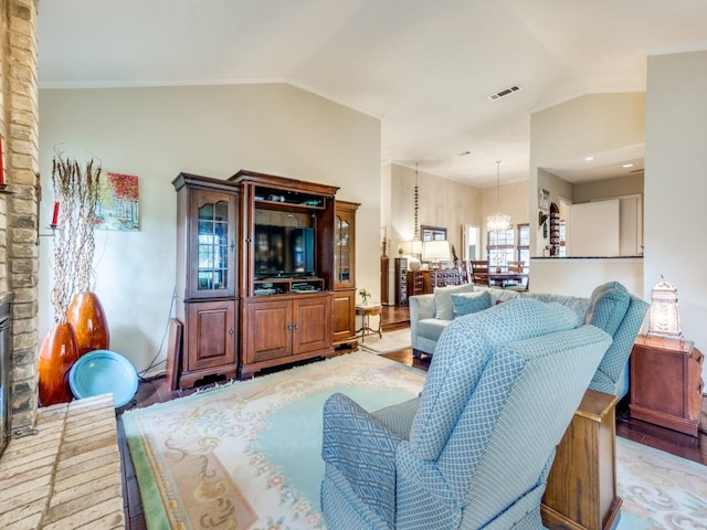 living room featuring light wood-type flooring, vaulted ceiling, and a chandelier