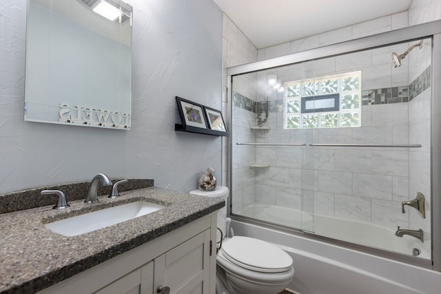 full bathroom with vanity, toilet, and combined bath / shower with glass door