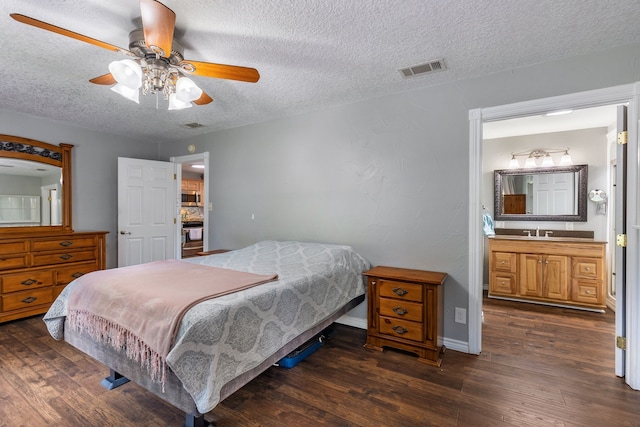 bedroom with connected bathroom, sink, ceiling fan, dark wood-type flooring, and a textured ceiling