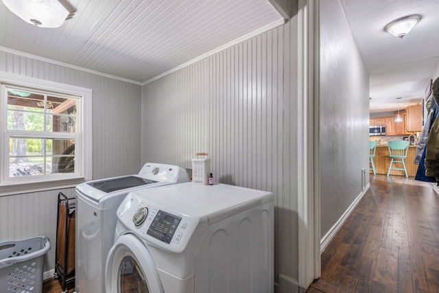 clothes washing area featuring dark hardwood / wood-style flooring, crown molding, and washer and clothes dryer