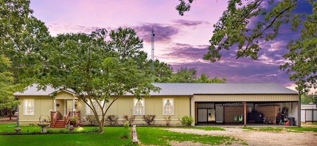 exterior space with metal roof, a front lawn, and dirt driveway