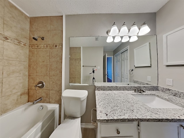 bathroom featuring toilet, washtub / shower combination, a textured ceiling, and vanity