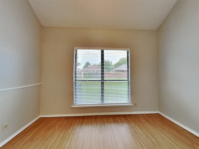 empty room featuring wood finished floors and baseboards