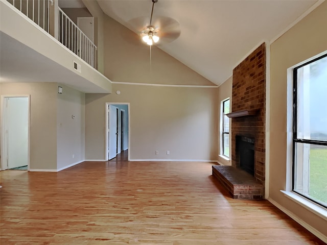 unfurnished living room with visible vents, light wood-style flooring, a brick fireplace, ceiling fan, and baseboards