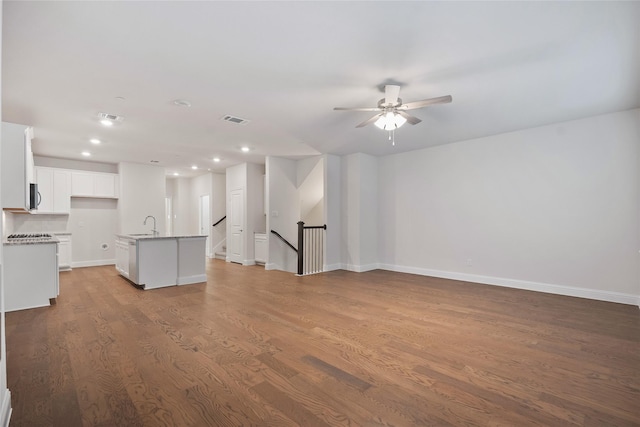 unfurnished living room featuring ceiling fan, light hardwood / wood-style flooring, and sink