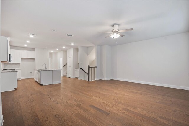 unfurnished living room featuring ceiling fan, light hardwood / wood-style flooring, and sink