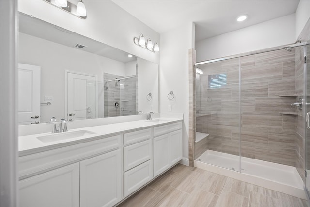 bathroom featuring vanity and a shower with shower door