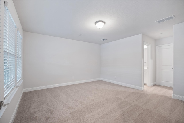 unfurnished room featuring light carpet